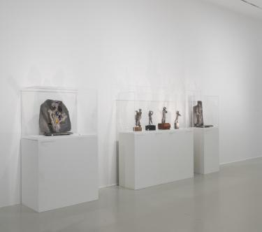 Vue d'une salle de l'exposition Germaine Richier avec plusieurs sculptures sur des socles.