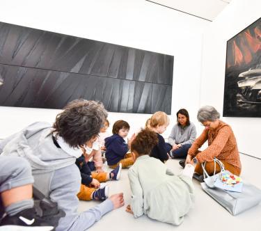 Dans une salles Soulages du musée, on voit un groupe d'assistantes maternelles avec des bébés et des poussettes.