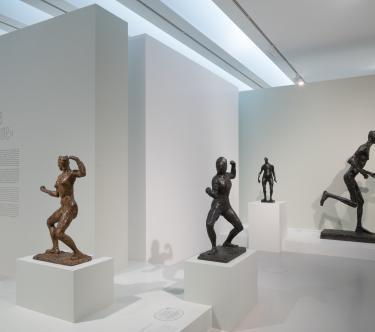 Vue d'une salle de l'exposition "Germaine Richier" montrant quatre sculptures de l'artiste : deux escrimeuses, un personnage debout et un personnage en train de courir.