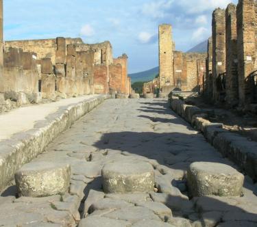 Vue d'une rue de Pompéi avec des pierres matérialisant les passages piétons.