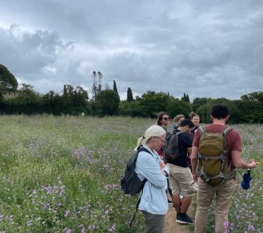 Dans les jardins en fleurs du domaine de Méric à Montpellier, un groupe de personnes en équipement de randonnée.