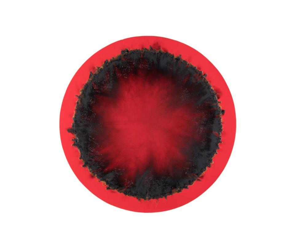 Une œuvre de Christian Jaccard représentant un rond rouge avec une zone brûlée en périphérie extérieure.